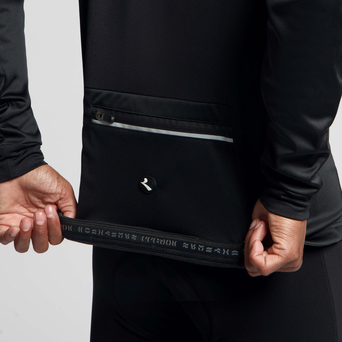 Detail Rogelli Core fietsjack heren zwart gedragen tailleband achterkant.
