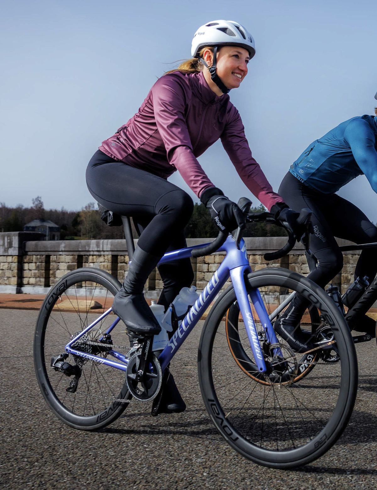 Vrouw in aubergine Rogelli Essential II winter fietsjack dames tijdens een rit op de racefiets in koel weer.