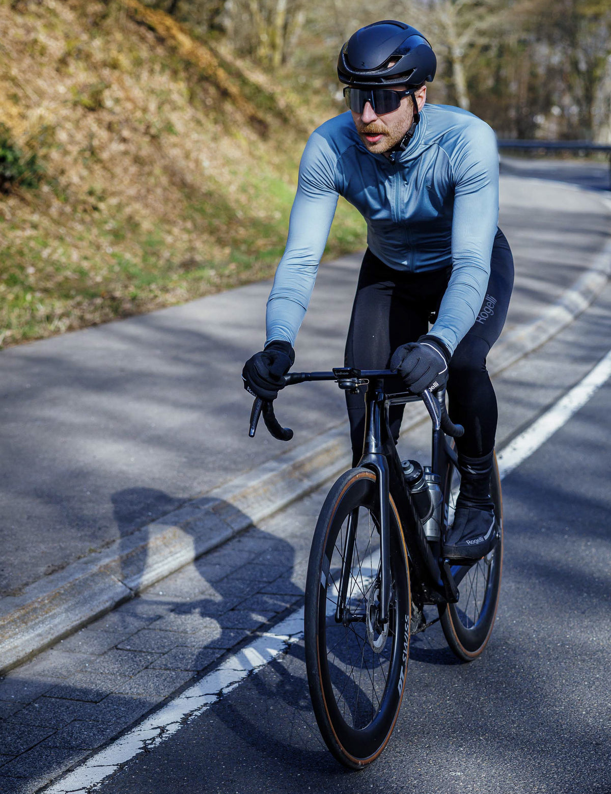 Man in grijs Rogelli Essential II fietsshirt heren met lange mouwen tijdens een rit op de racefiets.