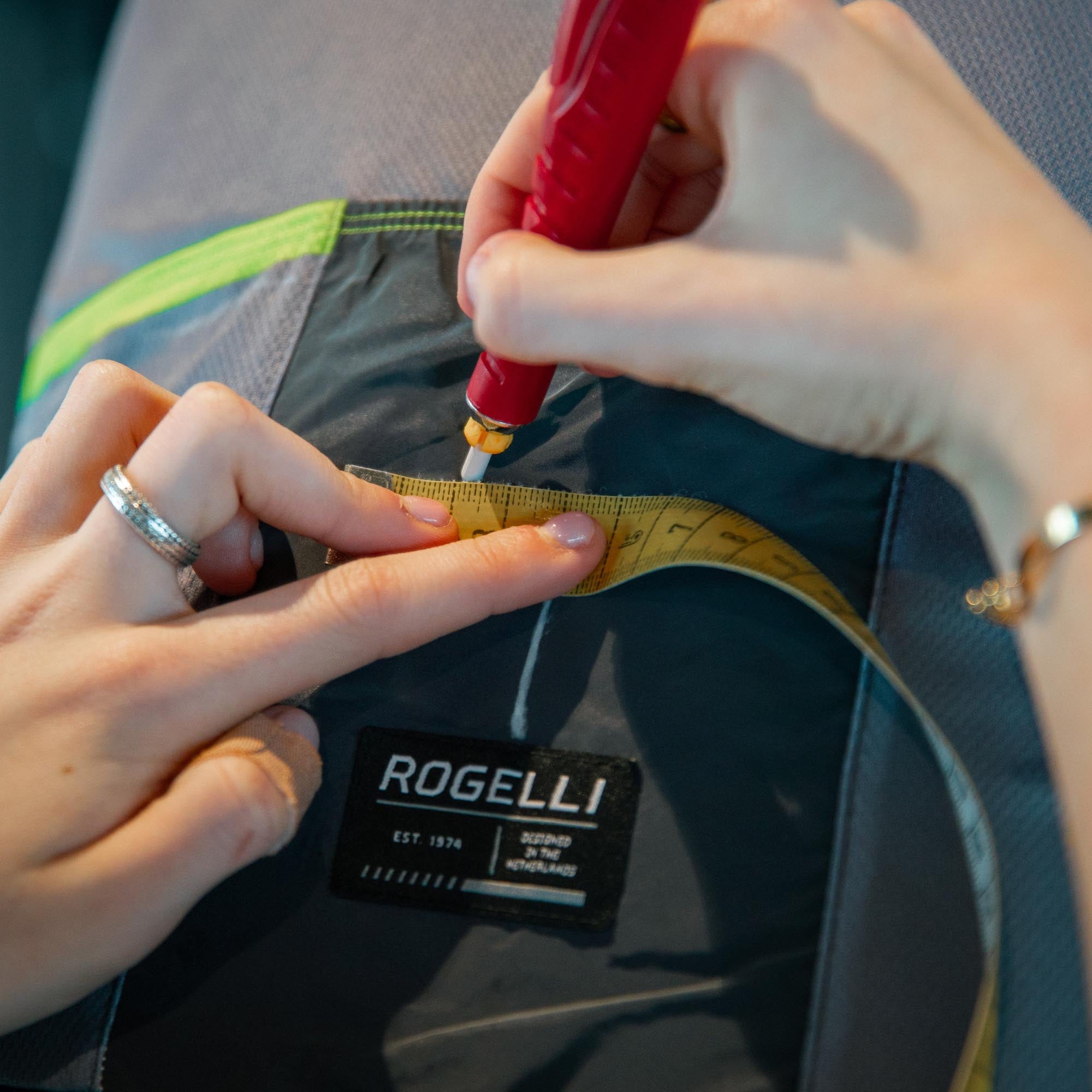Foto van een meetlint waarmee een fietsshirt van Rogelli opgemeten wordt.