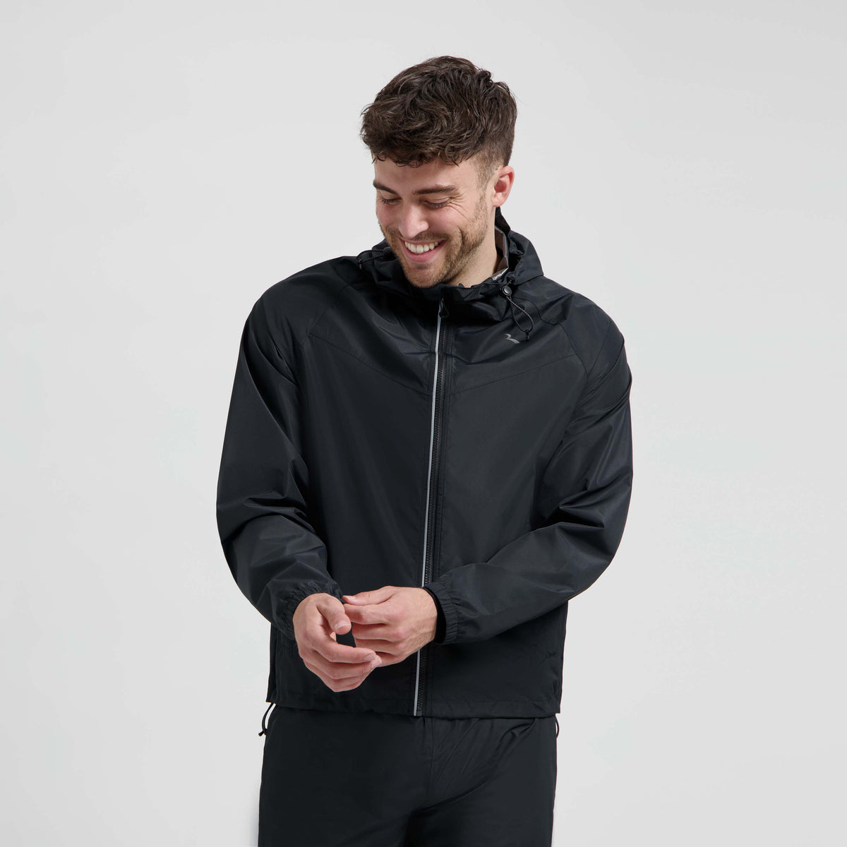 Rogelli Core Commuter regenjas unisex zwart gedragen door man voorkant.