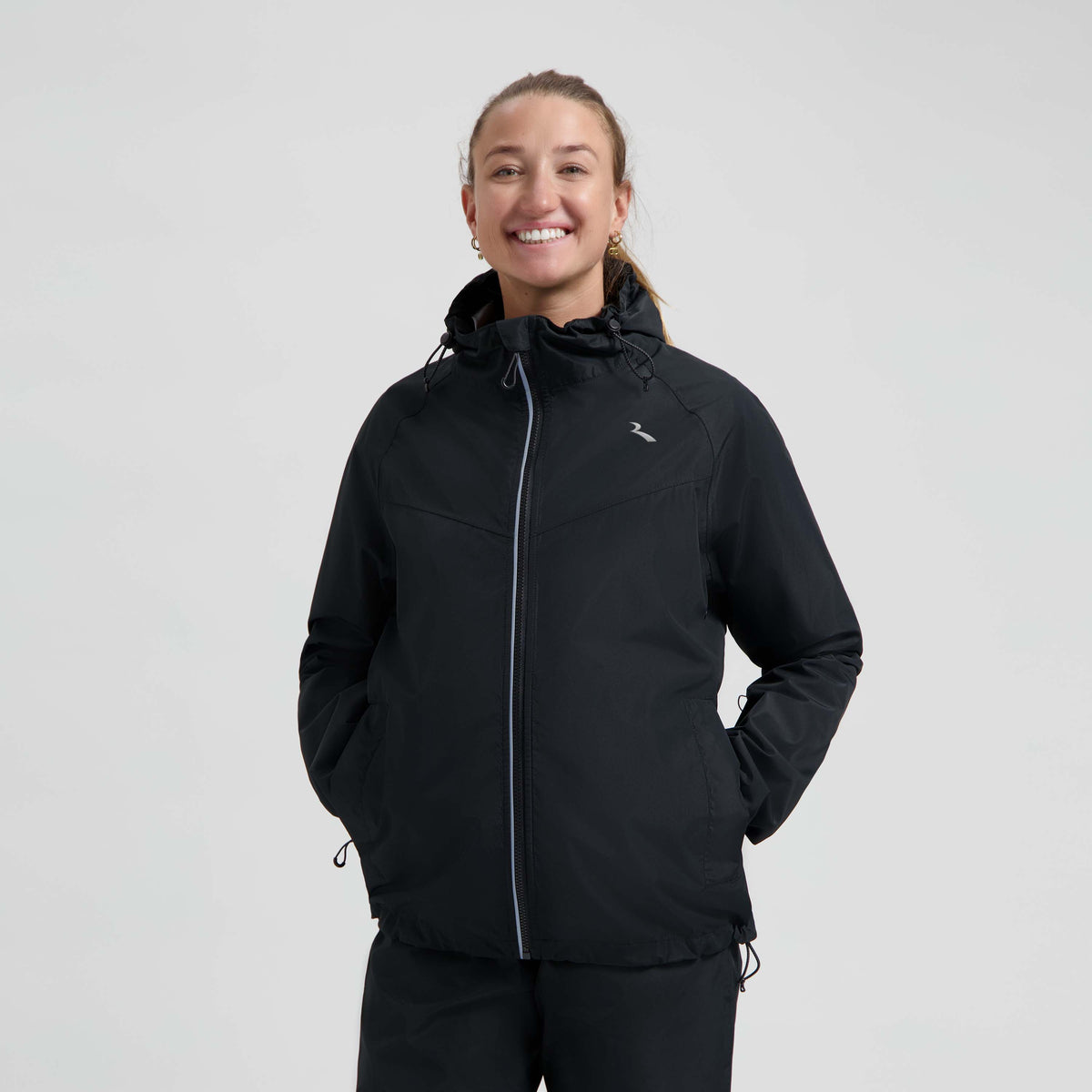 Rogelli Core Commuter regenjas unisex zwart gedragen door vrouw voorkant.