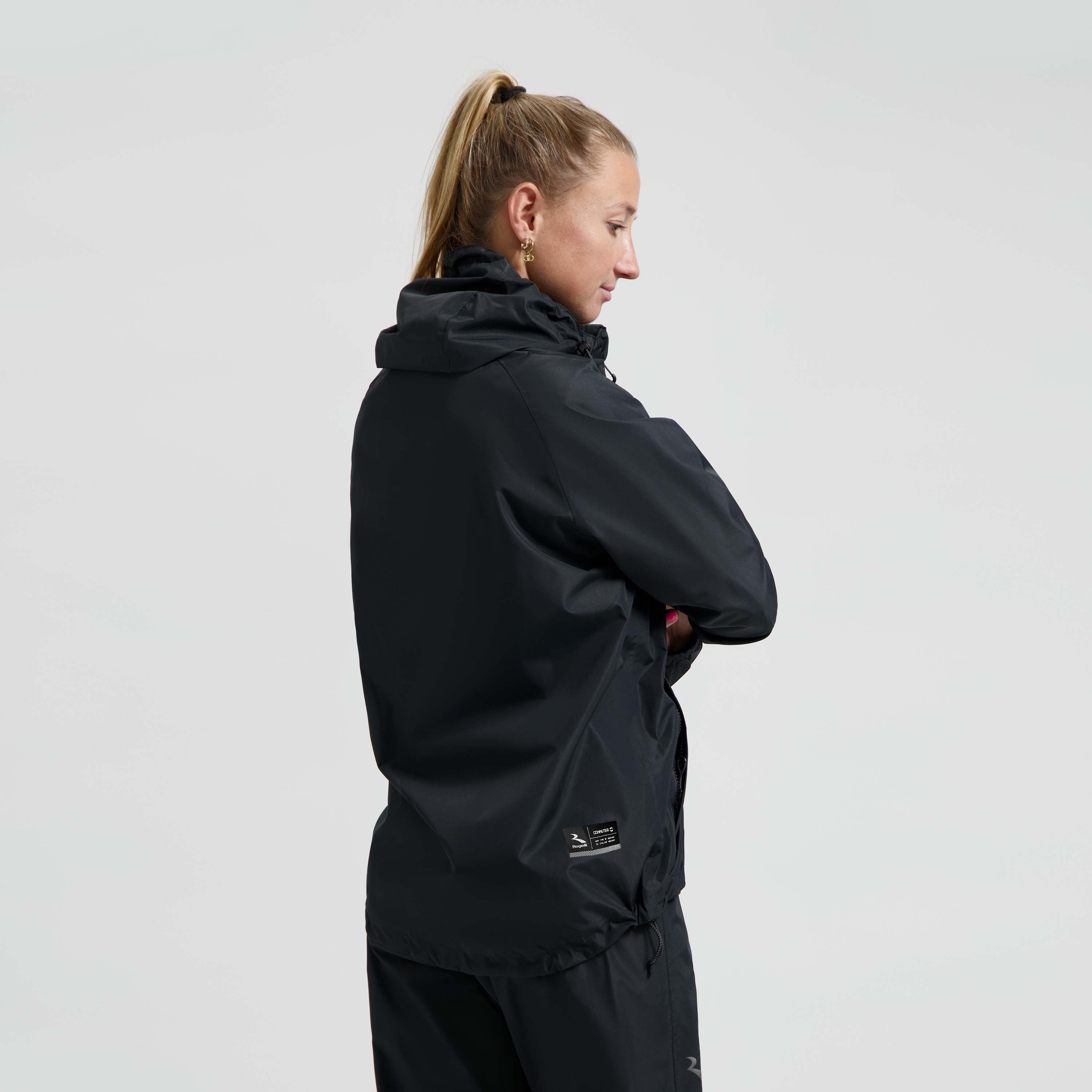 Rogelli Core Commuter regenjas unisex zwart gedragen door vrouw achterkant.