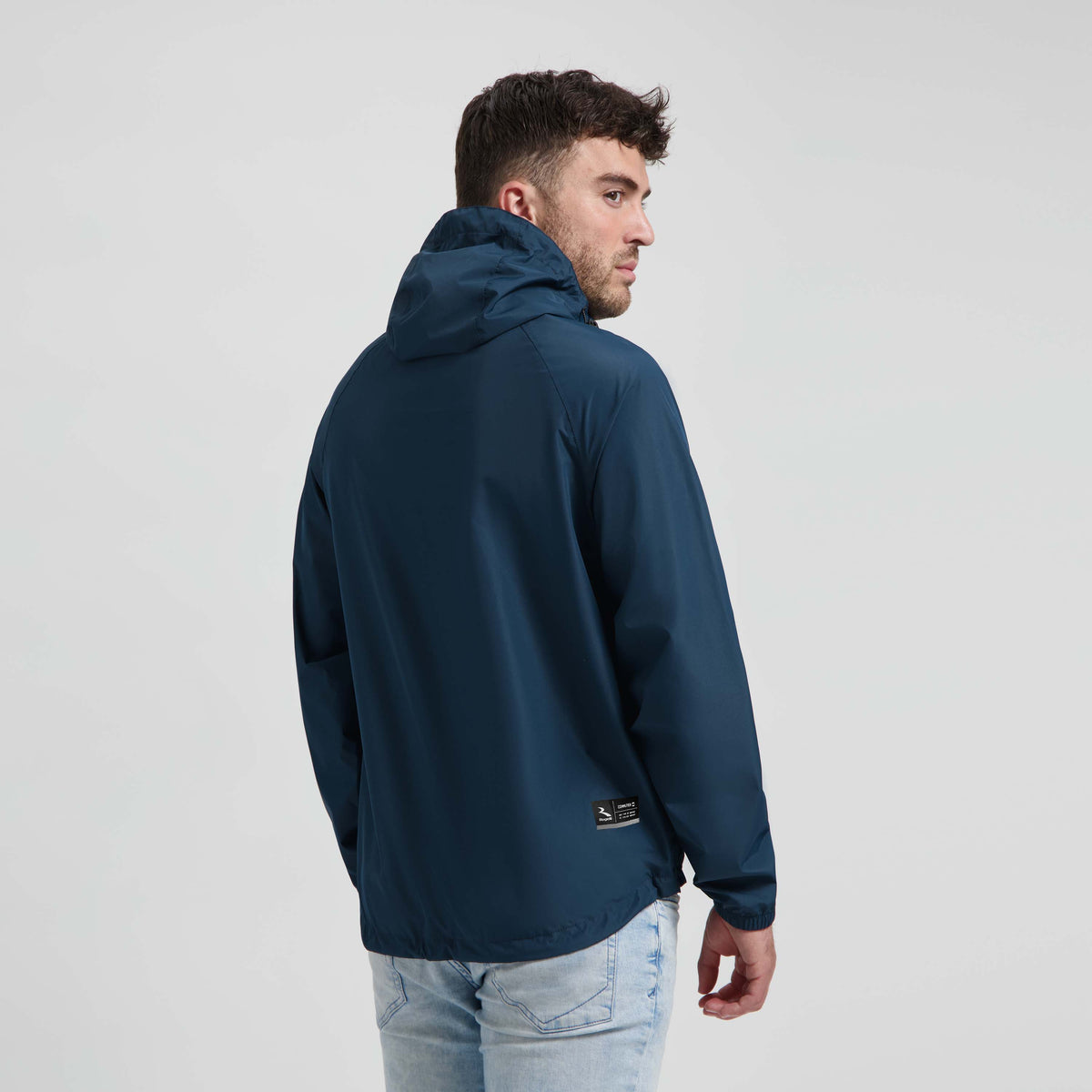 Rogelli Core Commuter regenjas blauw gedragen door man achterkant.