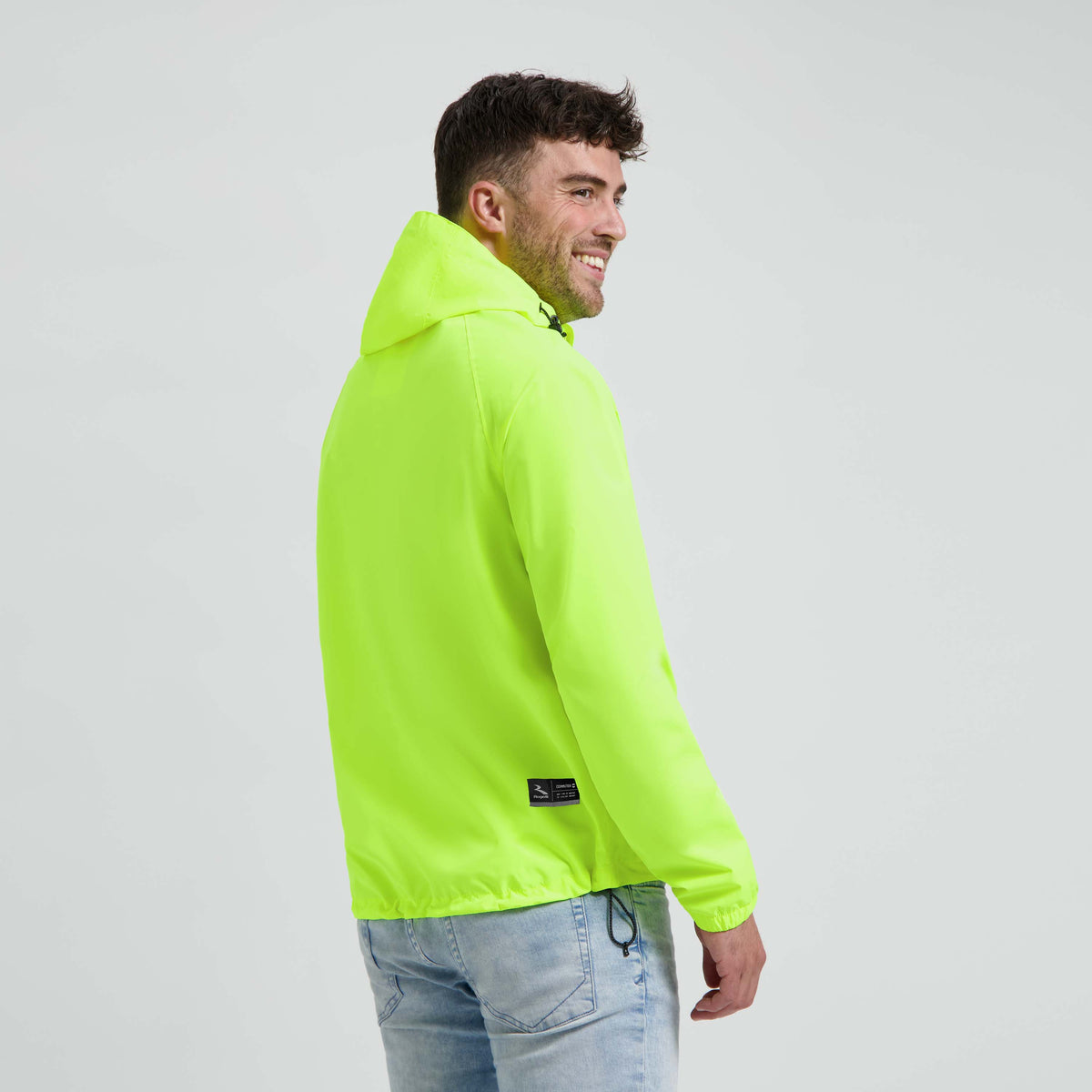 Rogelli Core Commuter regenjas unisex fluor gedragen door man achterkant.