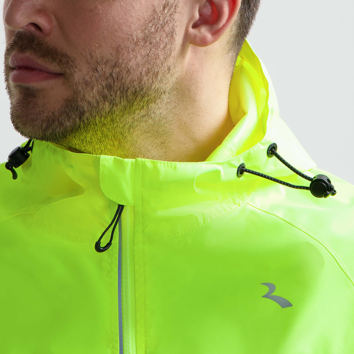 Detail ritssluiting Rogelli Core Commuter regenjas unisex fluor voorkant.