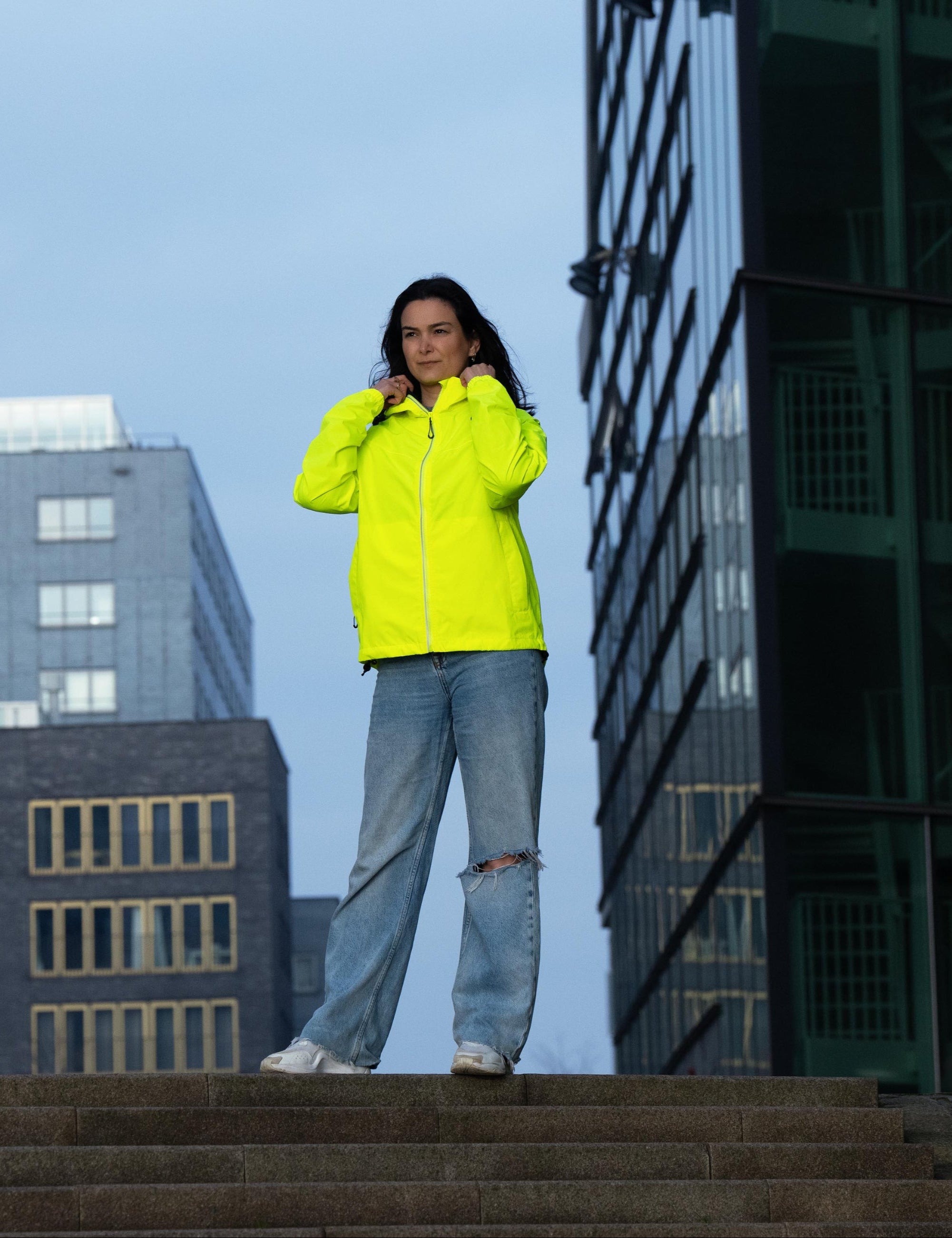 Vrouw draagt Rogelli Core Commuter regenjas – stijlvolle regenjas voor dagelijks fiets woon-werkverkeer.