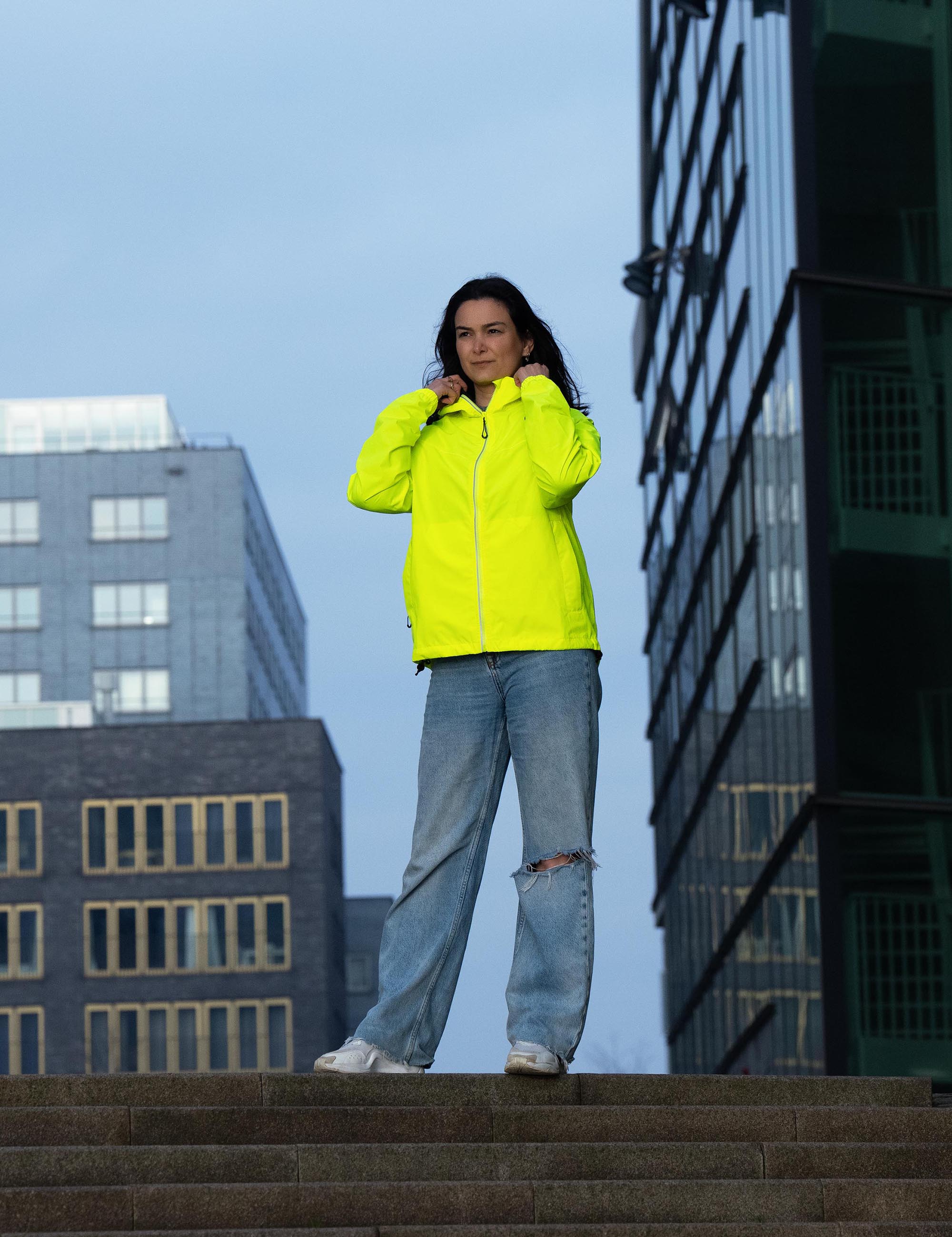 Vrouw draagt Rogelli Core Commuter regenjas – stijlvolle regenjas voor dagelijks fiets woon-werkverkeer.