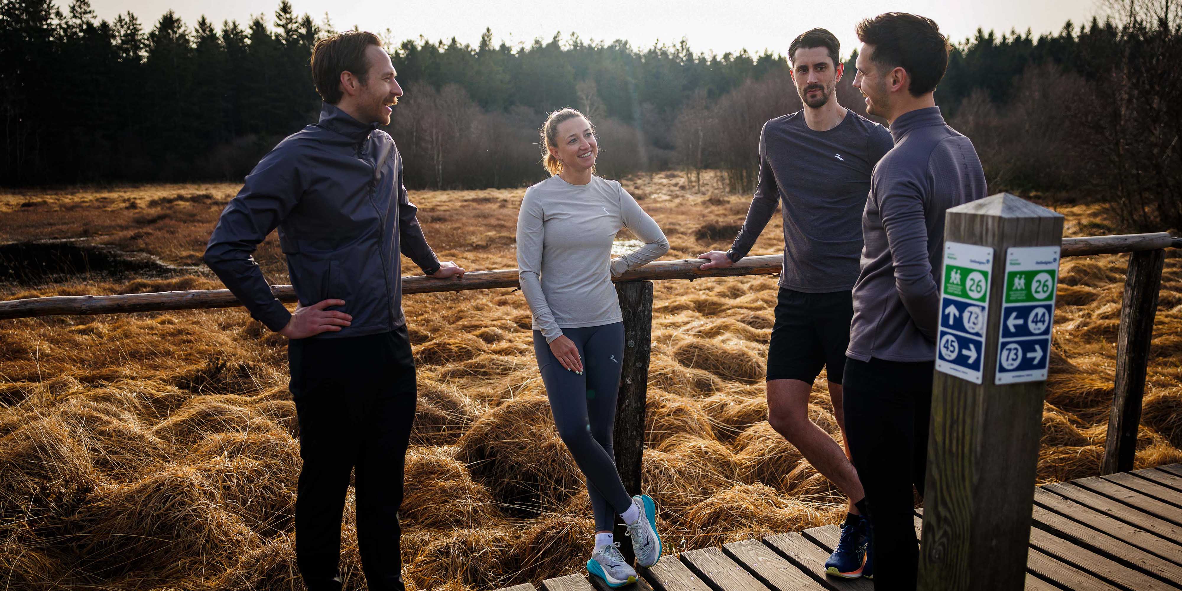 Groep hardlopers in Rogelli hardloopkleding tijdens een pauze in de buitenlucht.