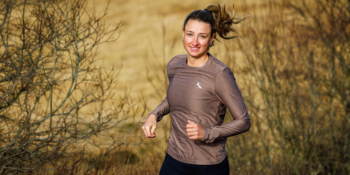 Vrouw in Rogelli hardloopshirt dames met lange mouwen tijdens het hardlopen in de buitenlucht.