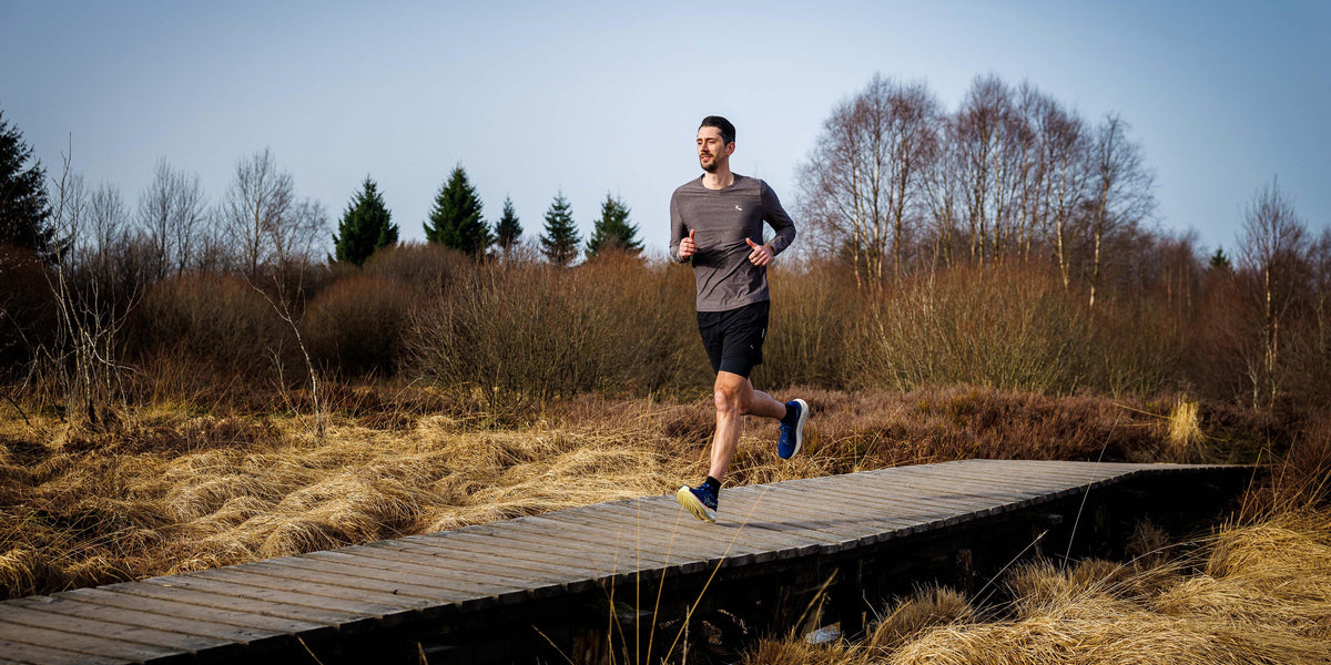 Man in Rogelli hardloopshirt heren tijdens het hardlopen in de buitenlucht.