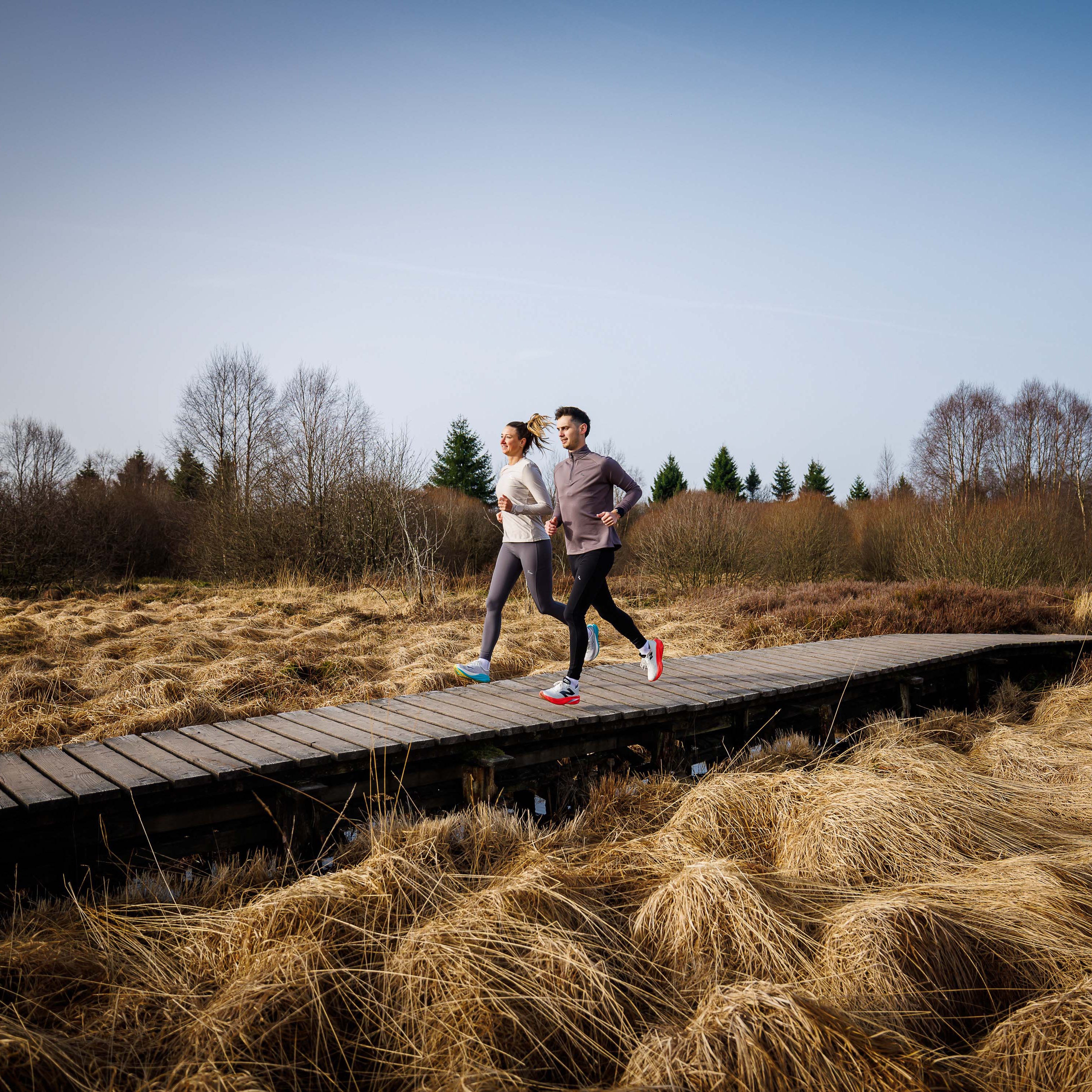 Man en vrouw in Rogelli hardloopkleding tijdens een run in de buitenlucht.