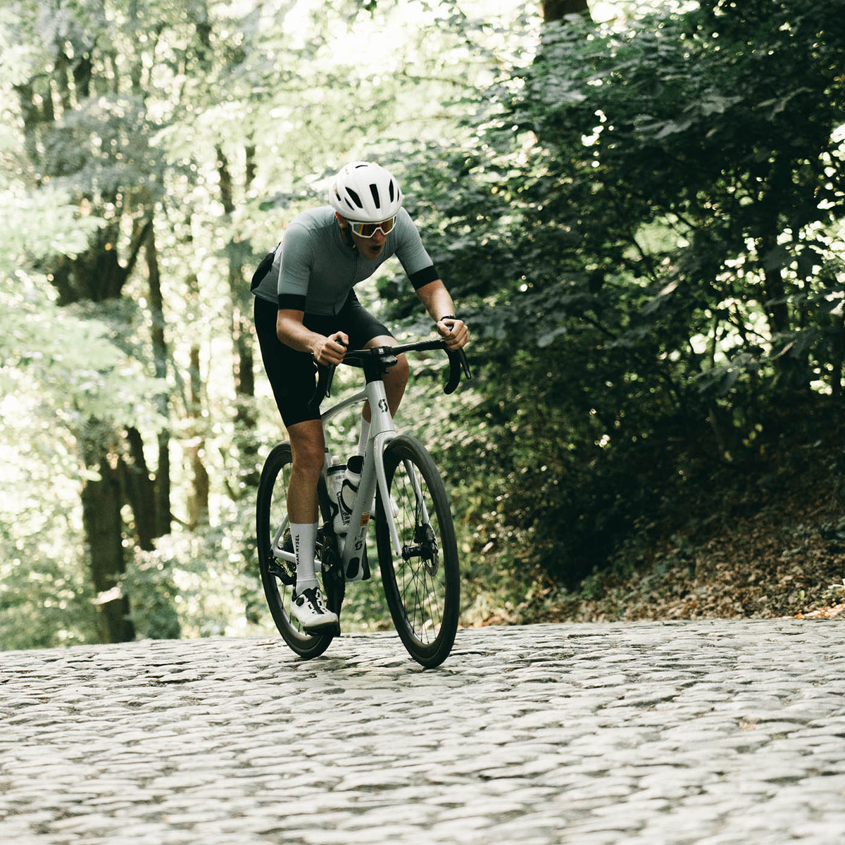 Dries fietst tijdens de Flandrien Challenge door het Vlaamse landschap over de kasseien.