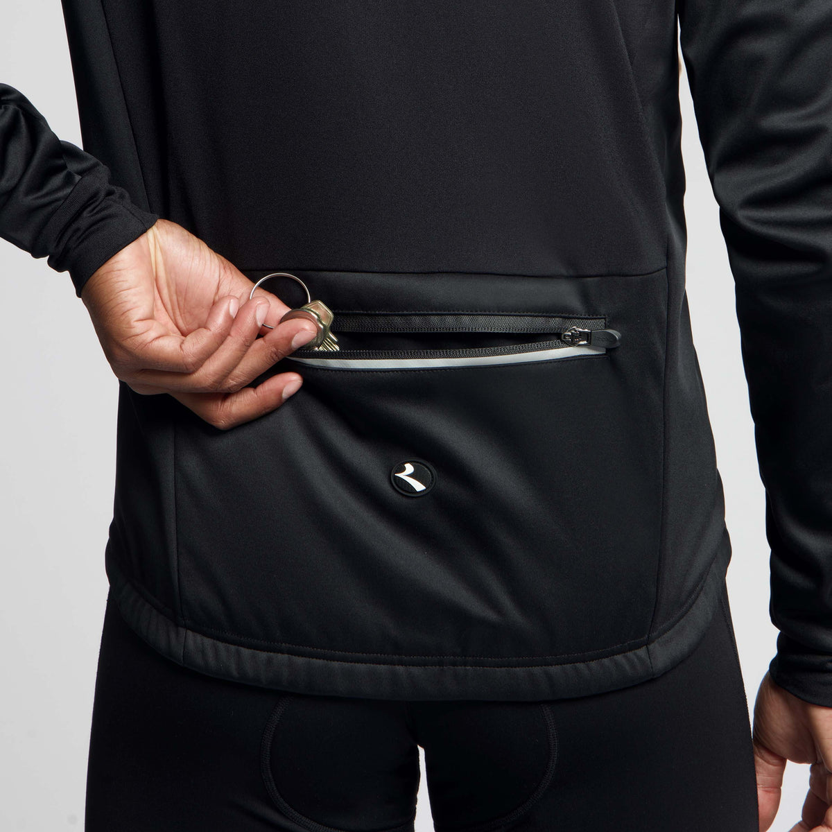 Detail Rogelli Core fietsjack heren zwart gedragen tailleband achterkant.