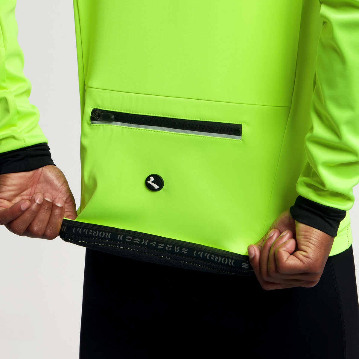 Detail Rogelli Core fietsjack heren fluor gedragen tailleband achterkant.