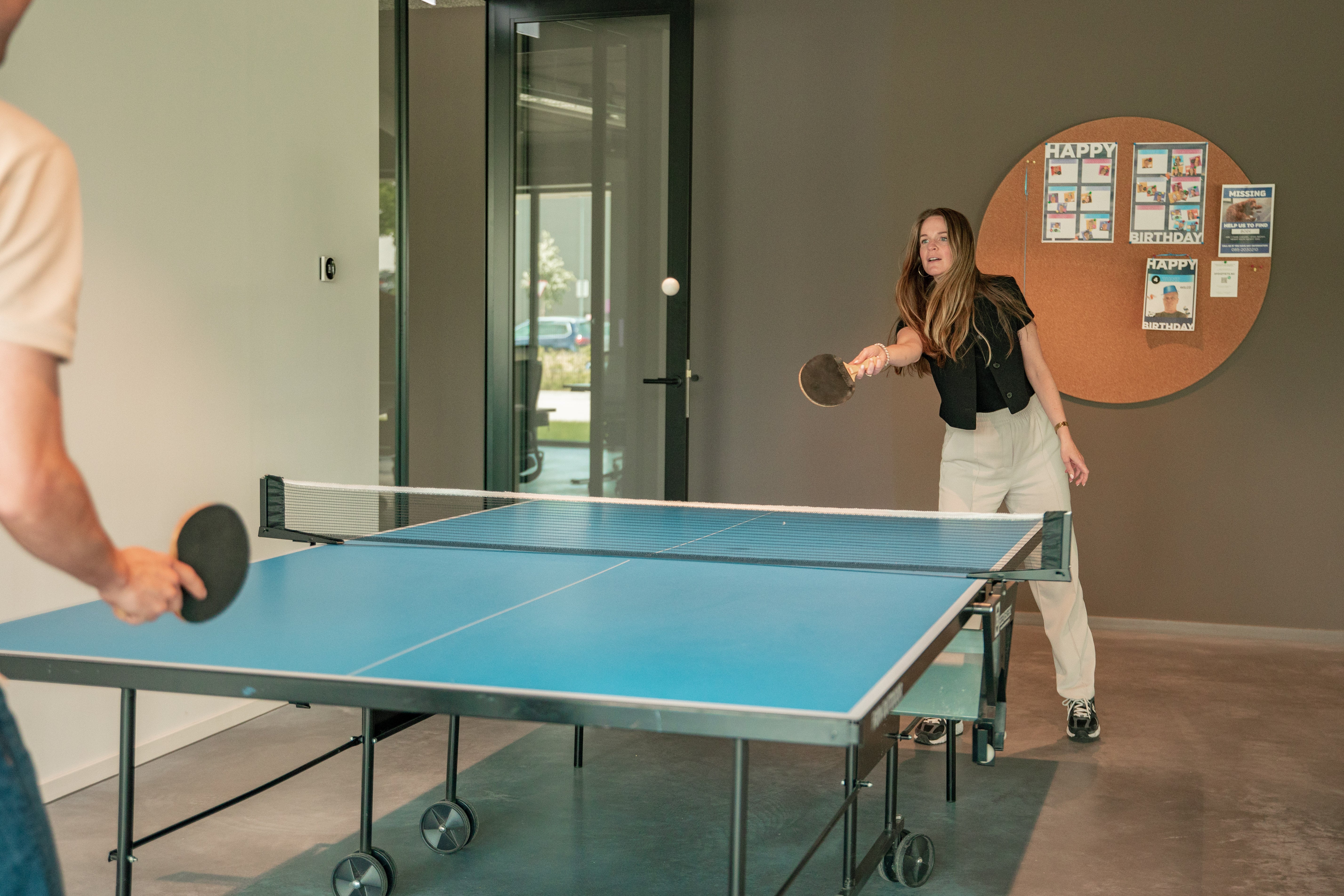 Foto van Christel tijdens het tafeltennissen in de kantine voor de 'werken bij' pagina.