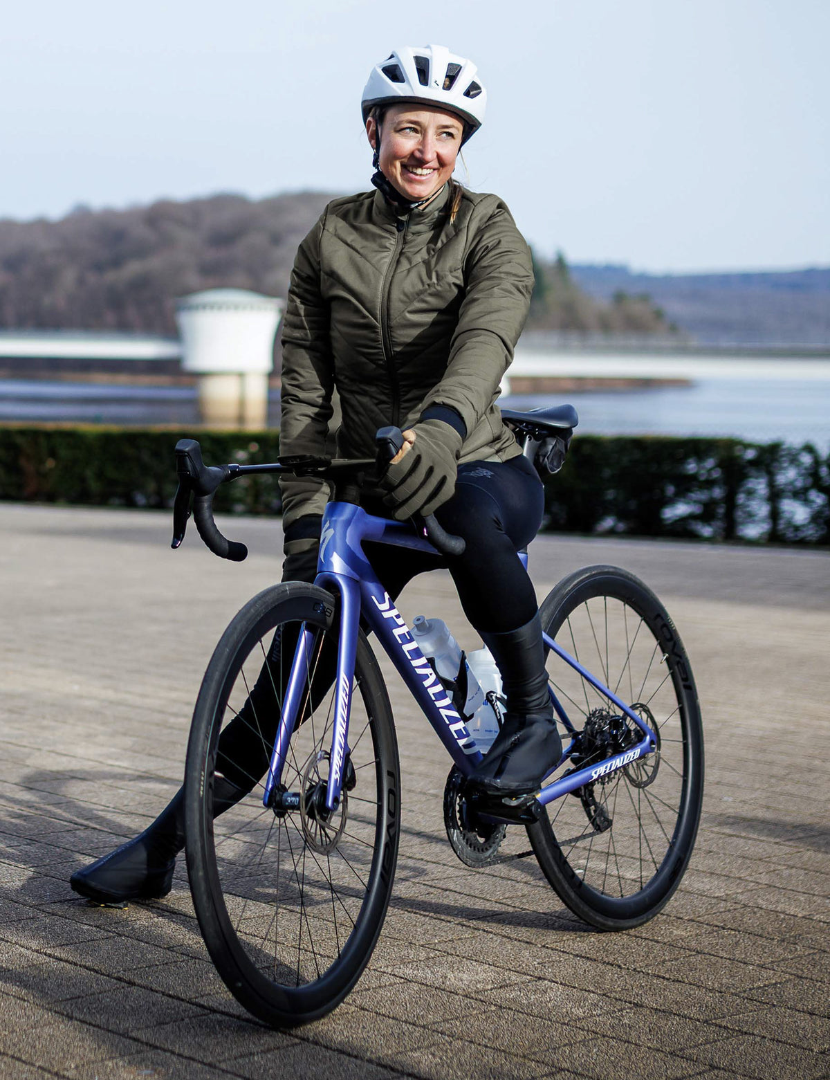 Vrouw in legergroen Rogelli Element winter fietsjack dames op de racefiets in koud weer.