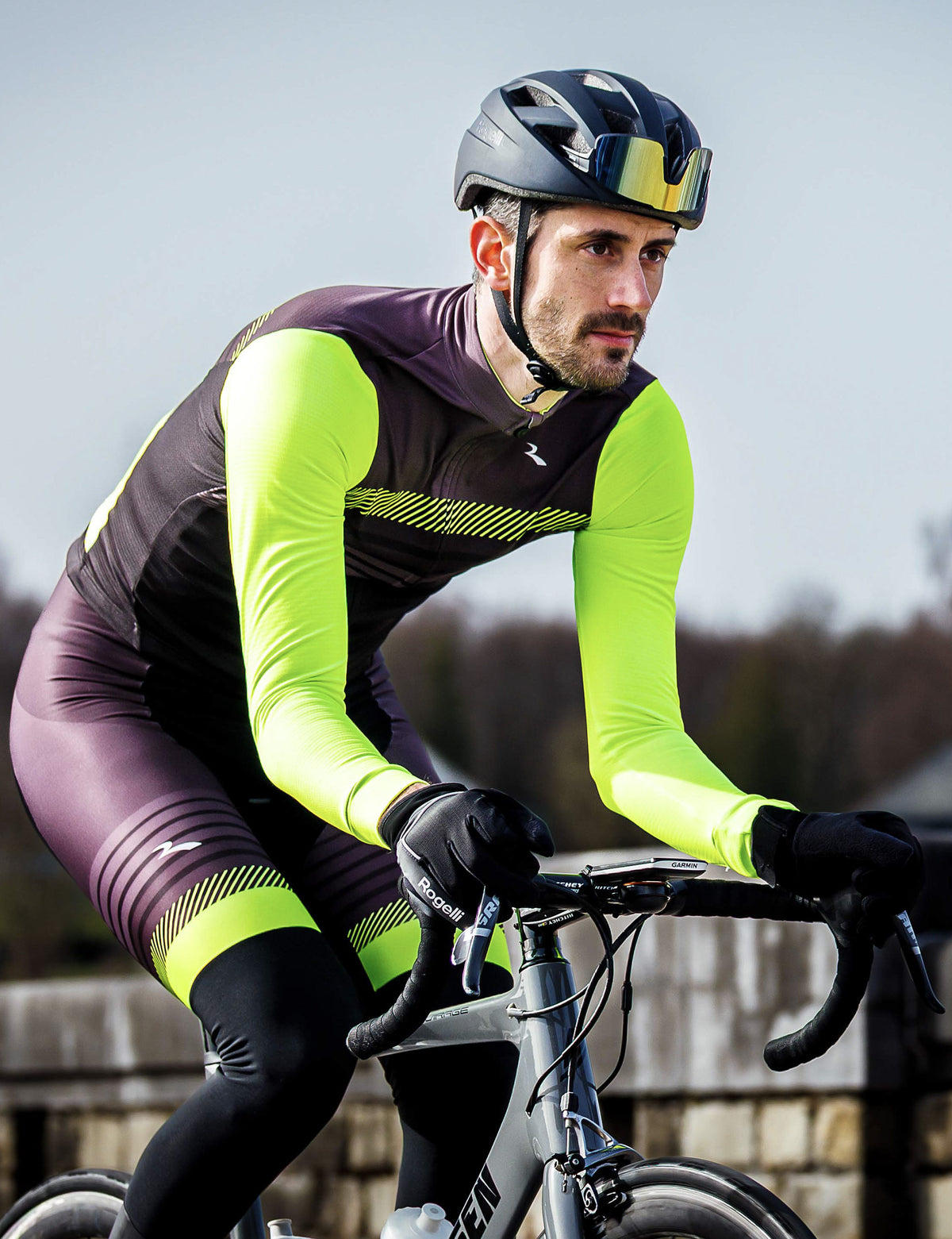 Man in zwarte Rogelli Stryde bibtight met fluoraccenten op de racefiets tijdens een rit in koel weer.