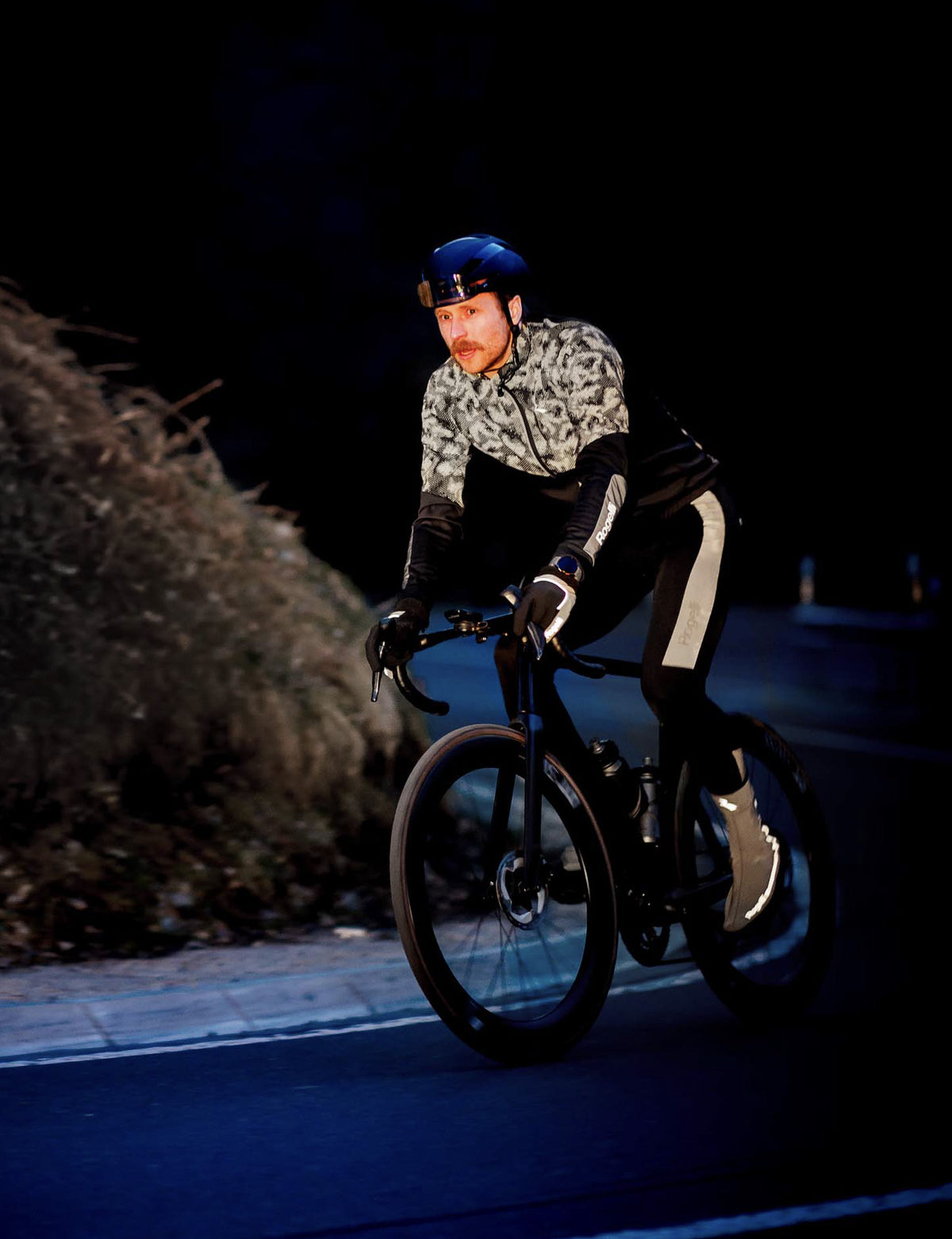 Wielrenner met Rogelli Hi Vis Essential fietsjack en fietsbroek voor extra zichtbaarheid in het donker.