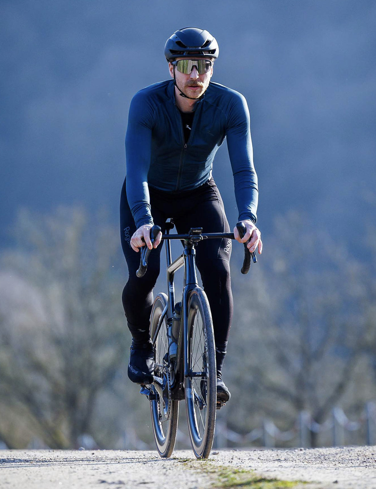 Man in blauw Rogelli Essential Light fietsshirt heren met lange mouwen tijdens een rit op de racefiets.