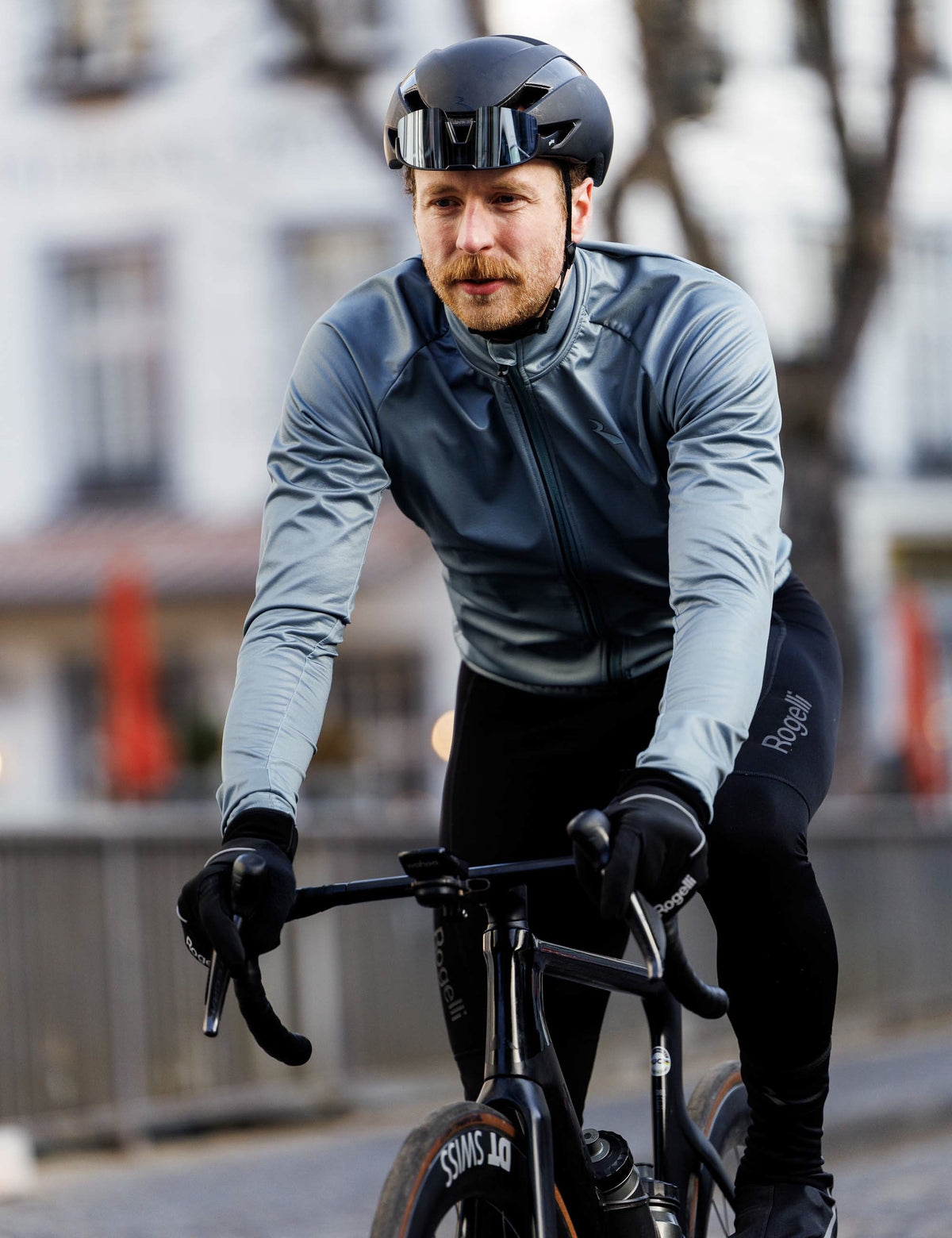 Man in grijs Rogelli Essential II winter fietsjack heren tijdens een rit op de racefiets in koud weer.