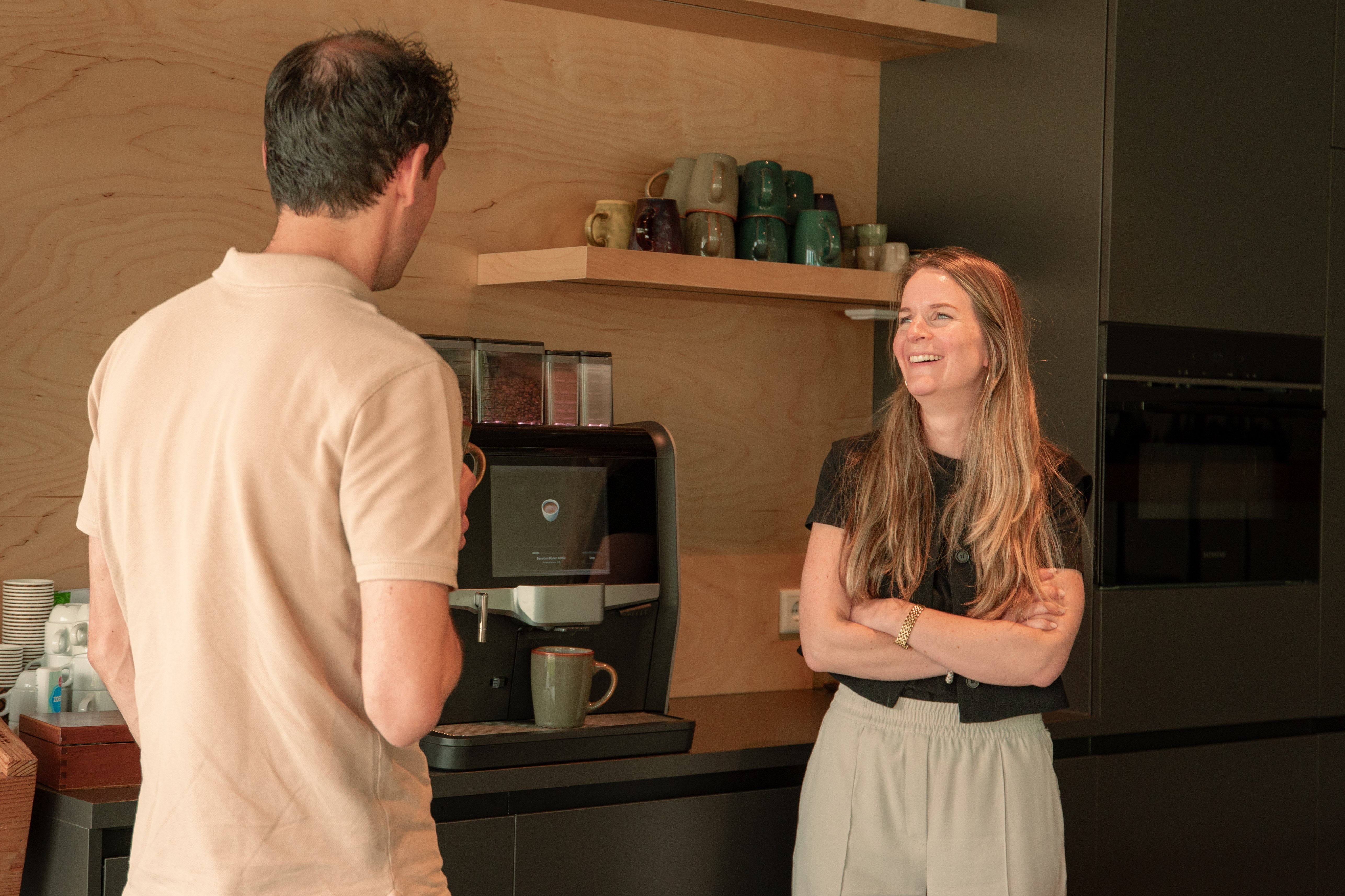 Foto van Michiel en Christel bij het koffiezetapparaat voor de pagina 'werken bij'.