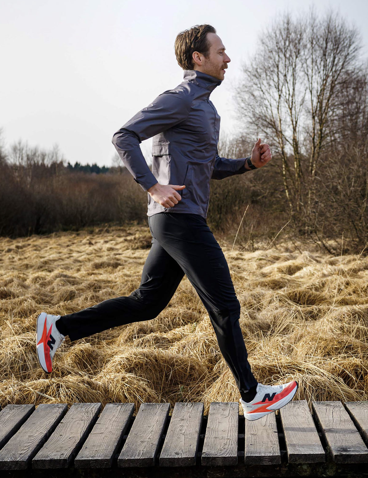 Man in zwarte Rogelli Essential hardloopbroek heren tijdens het hardlopen in de buitenlucht.