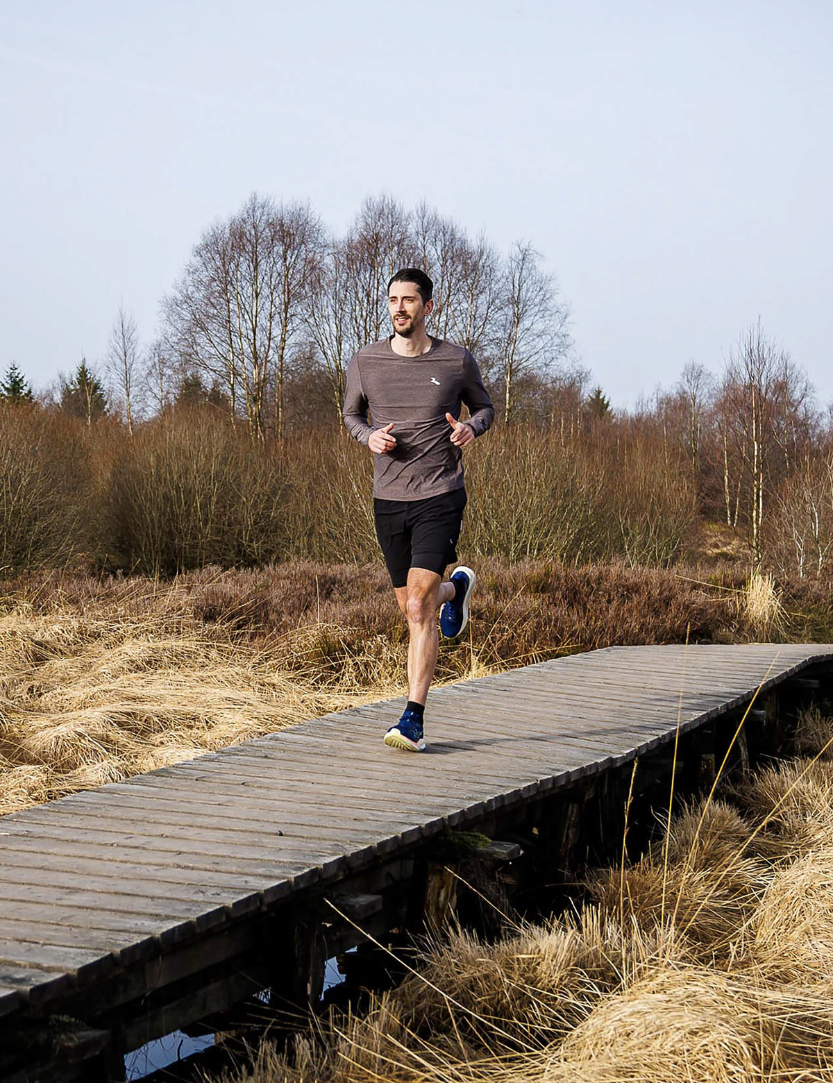 Man in Rogelli Essential hardloopshirt heren in plumkitten tijdens het hardlopen in de buitenlucht.