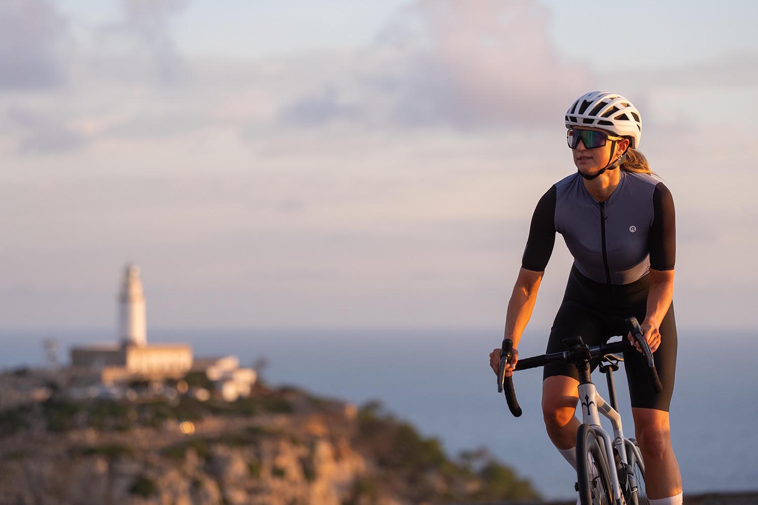 Wielrenster in Rogelli fietsshirt tijdens een zomerse fietstocht langs de kust.