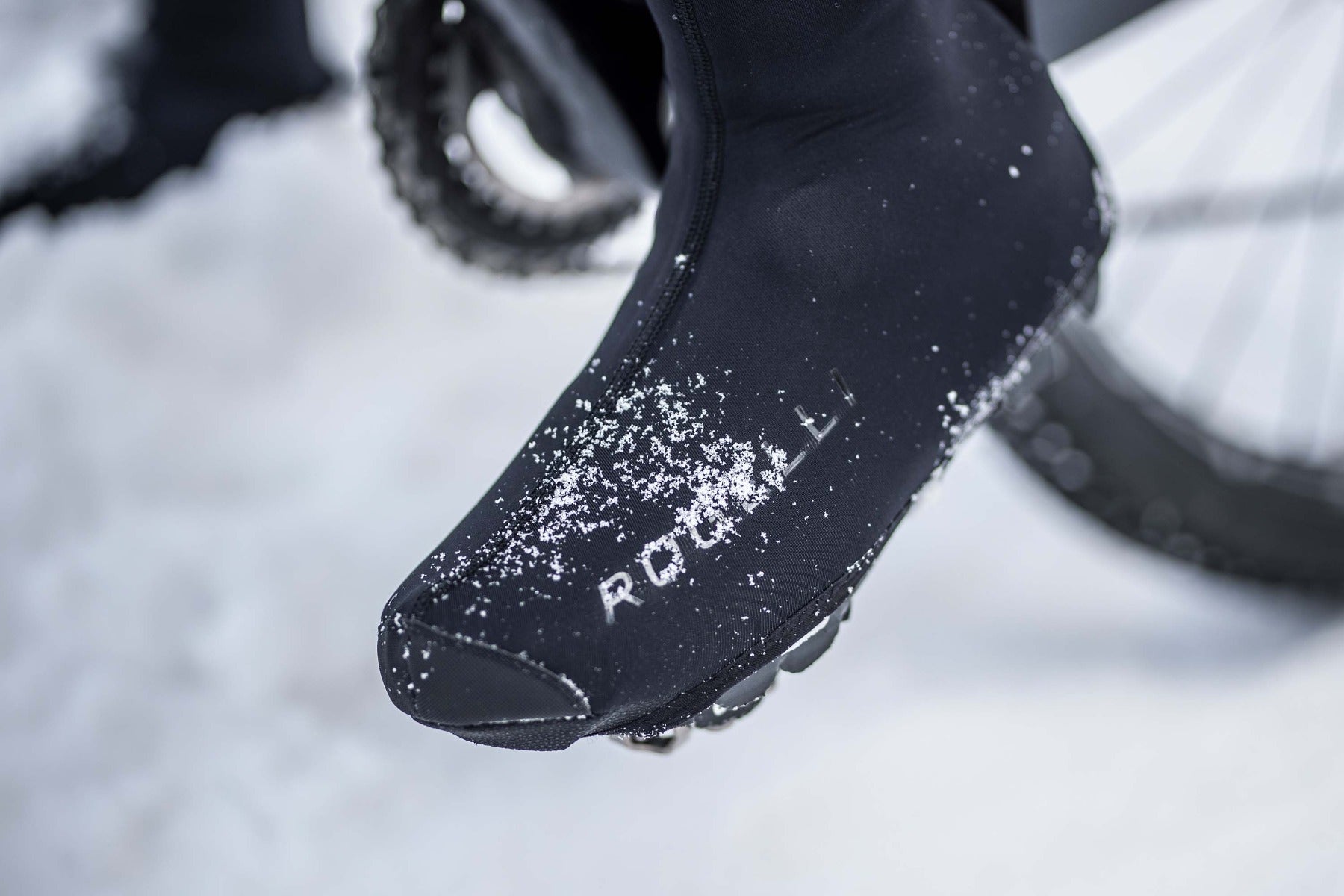 Fietser met overschoenen wielrennen in de sneeuw – warme en droge voeten tijdens winterritten.