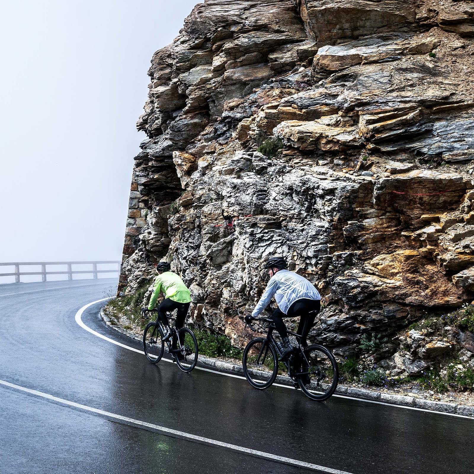 Twee wielrenners met Rogelli regenjack – uitleg wanneer kies je regenjack of windjack wielrennen.