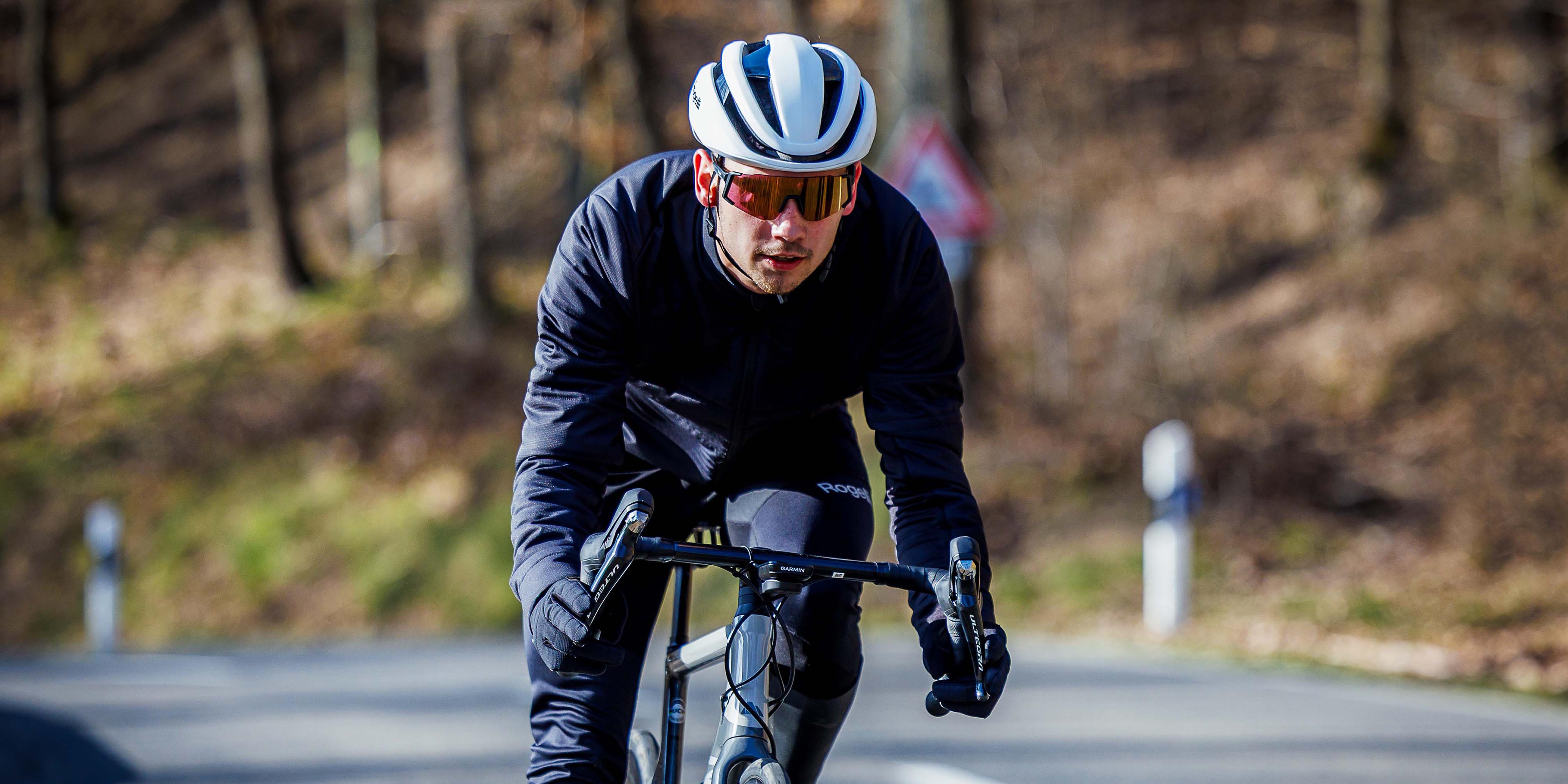 Man in Rogelli fietsaccessoires heren met helm, fietsbril en handschoenen tijdens een rit.
