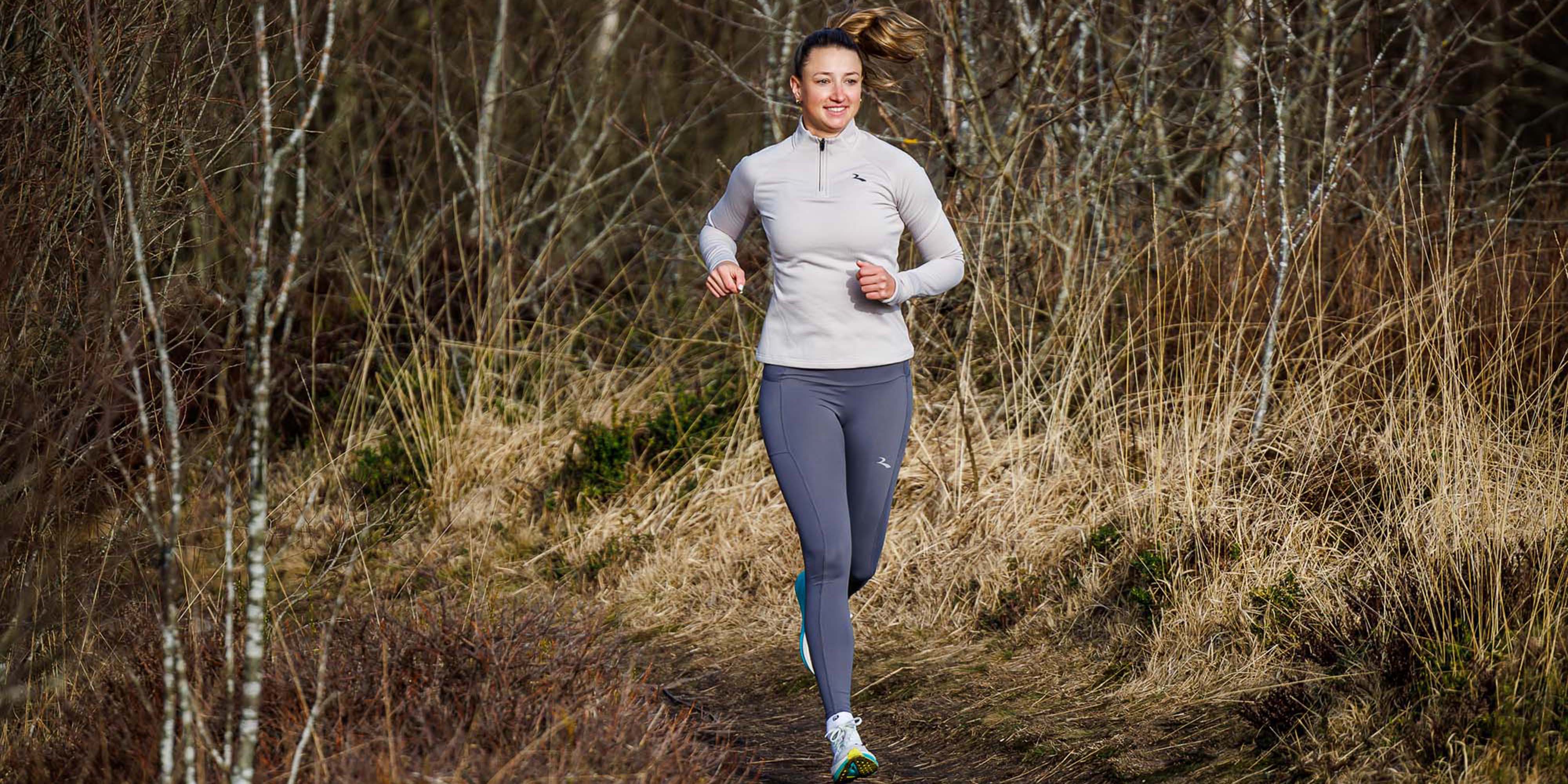 Vrouw in Rogelli hardloopkleding dames tijdens een ontspannen run in de buitenlucht.