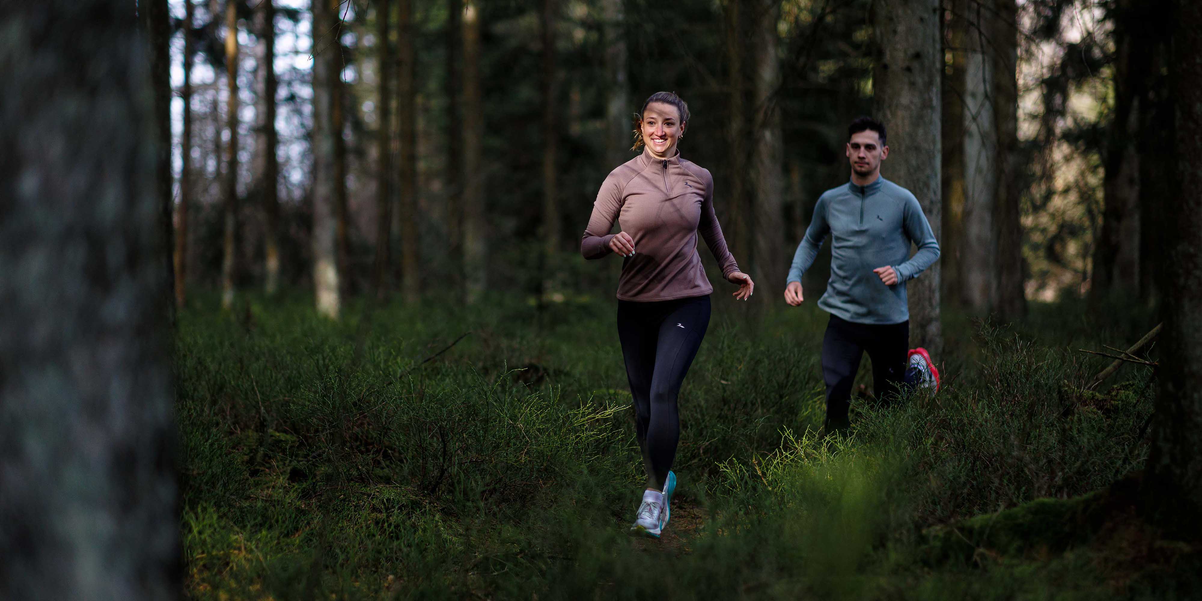 Vrouw in Rogelli hardlooptop dames met lange mouwen tijdens het hardlopen in het bos.