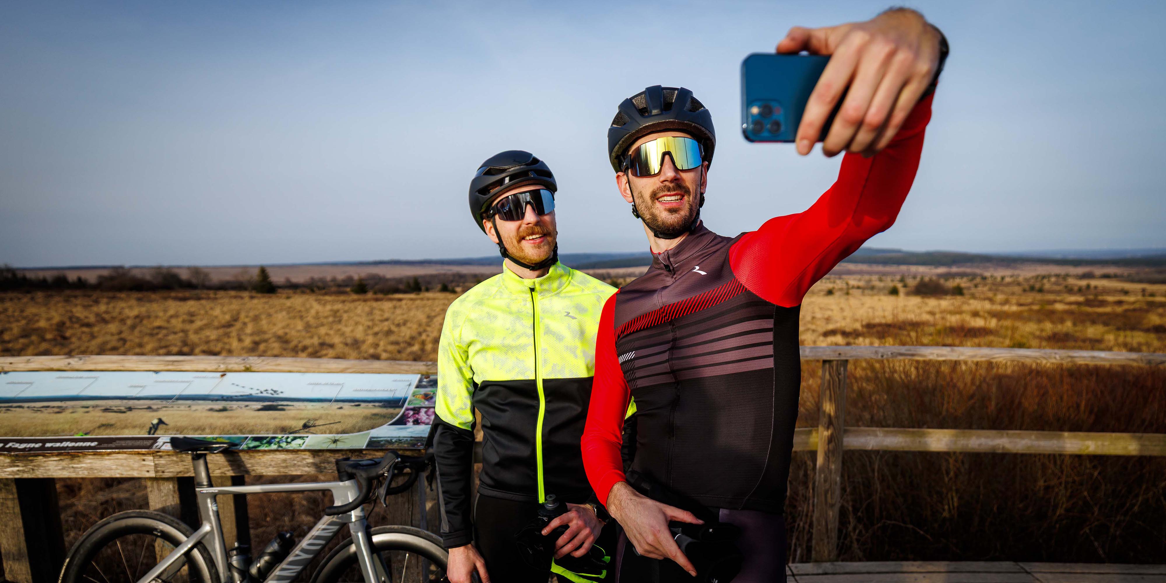 Twee mannen in Rogelli fietskleding heren maken een selfie tijdens een fietstocht.
