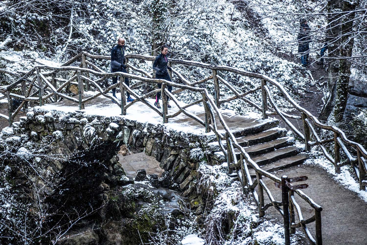 Twee hardlopers rennen over een besneeuwde brug