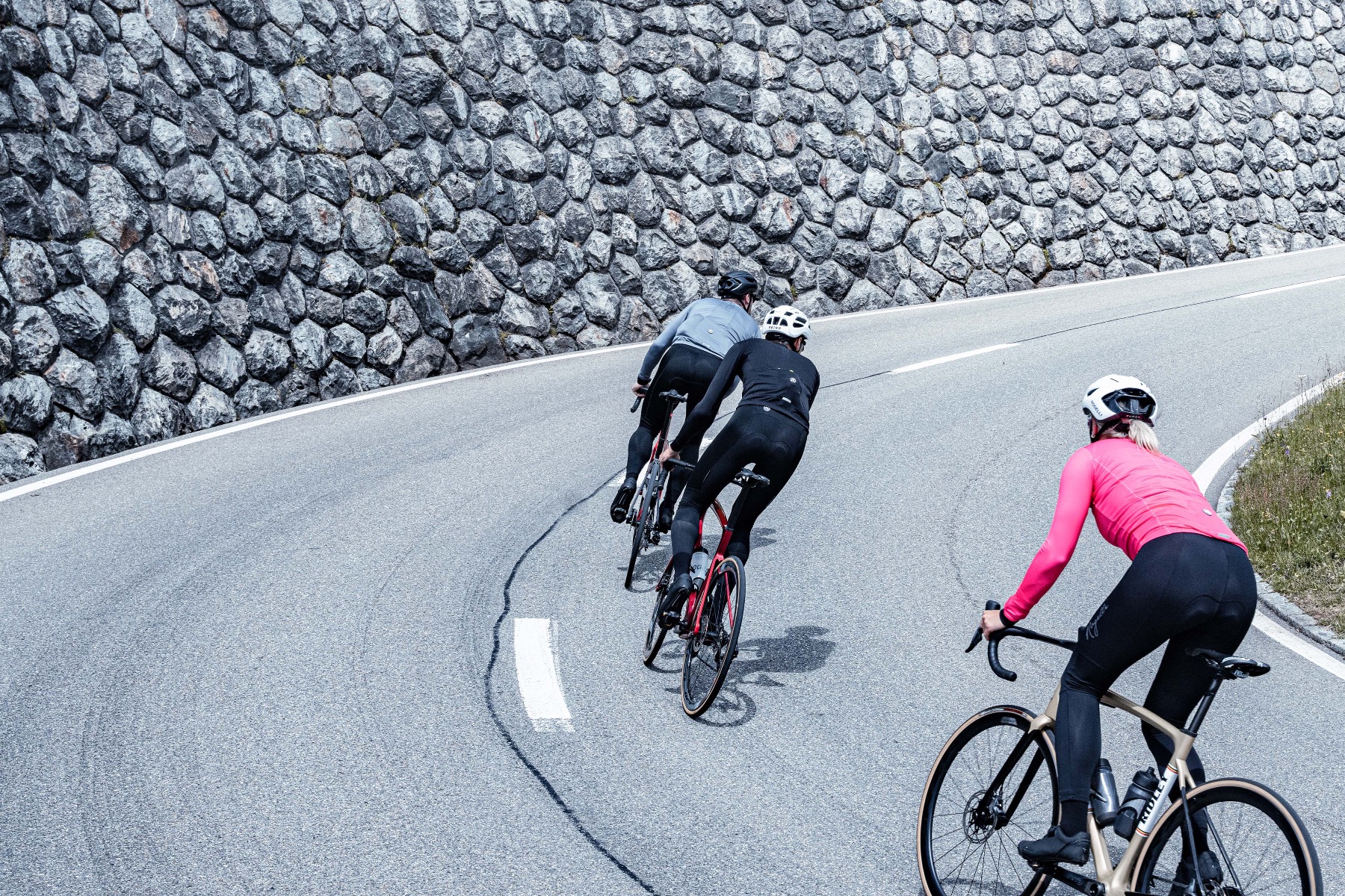 Groep fietsers werkt samen tijdens een steile klim. Rogelli fietskleding biedt ondersteuning en comfort.