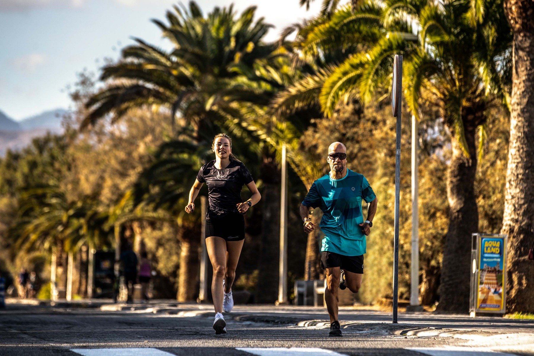 Een man en een vrouw rennen samen in Rogelli hardloopkleding, genietend van hun gezamenlijke run.