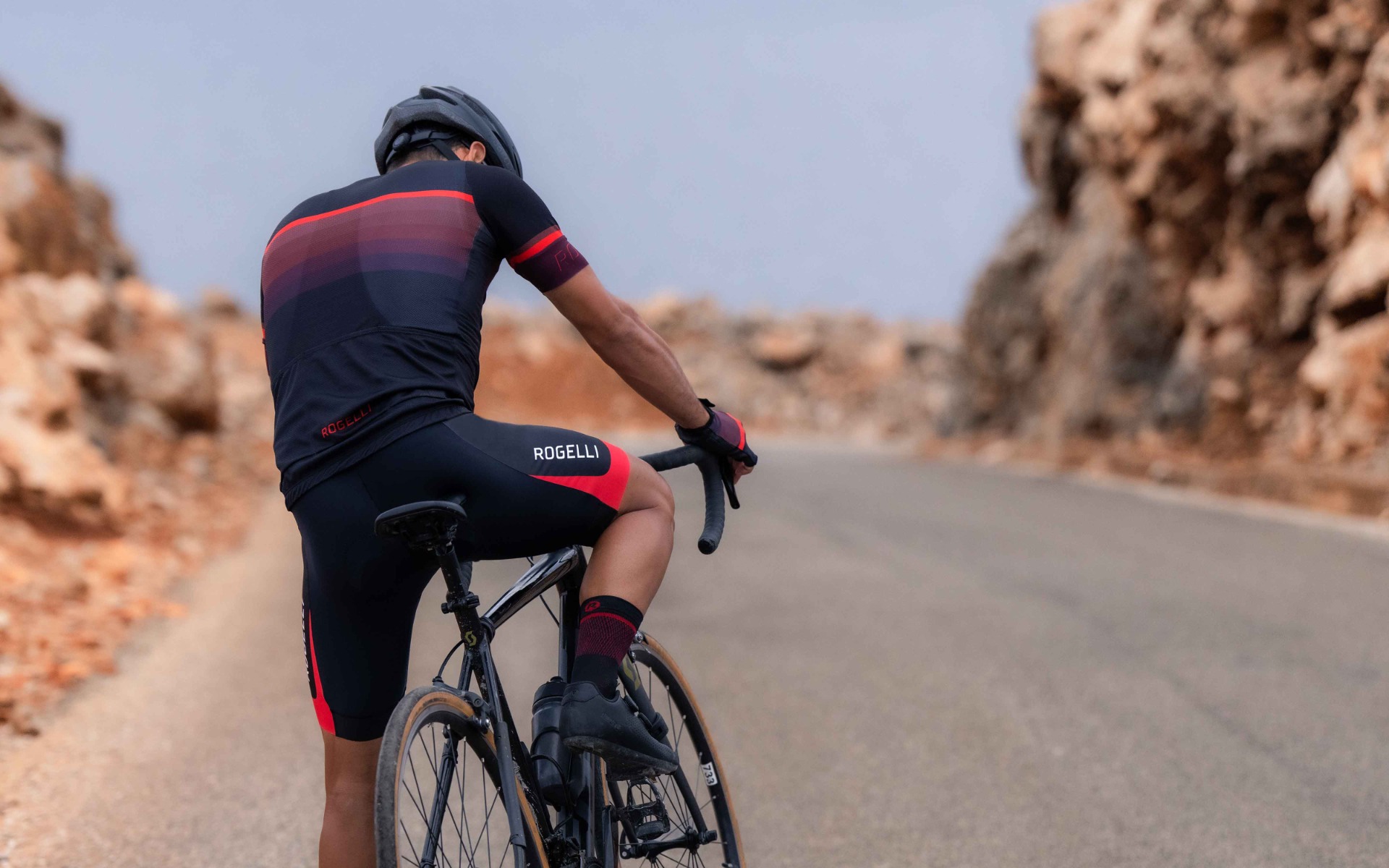 Een wielrenner laat een stijlvolle afstemming zien door zijn fietsbroek perfect te laten passen bij zijn volledige wieleroutfit van Rogelli.