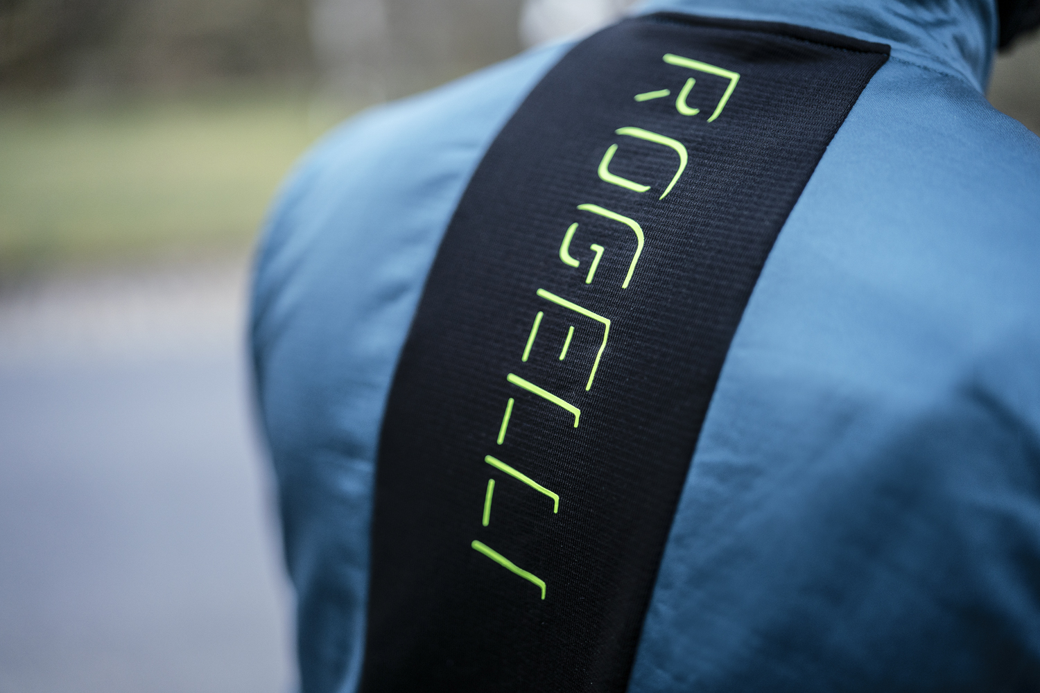 Een close-up onthult het hoogwaardige ontwerp en de functionaliteit van een Rogelli fietsjack voor heren, met aandacht voor detail en prestaties op de weg.