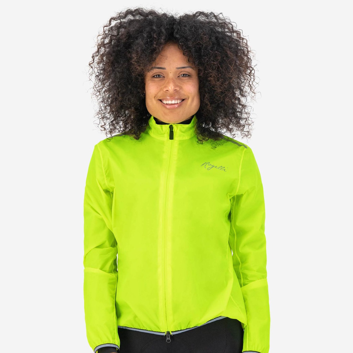 Woman wearing the Rogelli Essential rain jacket, providing protection against rain and splashing water with its extended back panel