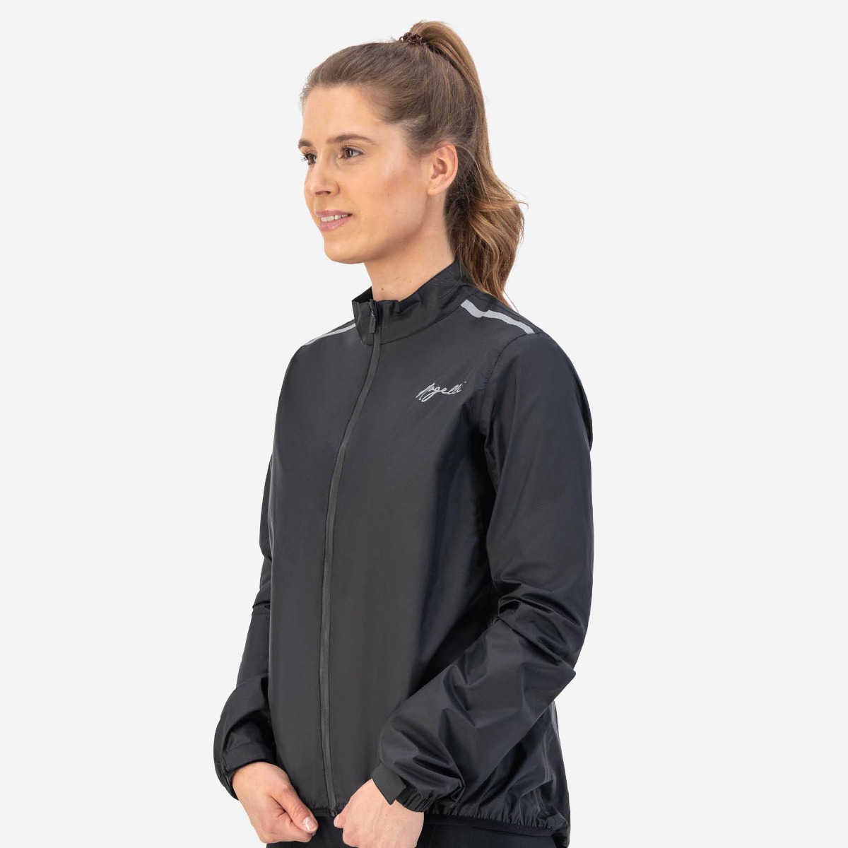 Female cyclist is wearing the Rogelli Core rain jacket for protection against rain