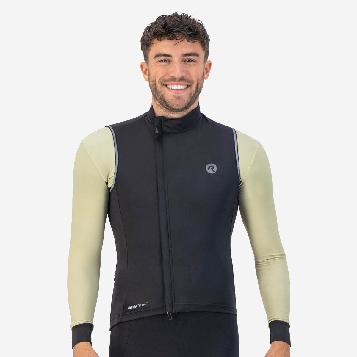Cyclist wearing the Rogelli Essential Body Vest over a long-sleeve cycling shirt for optimal protection against wind and cold