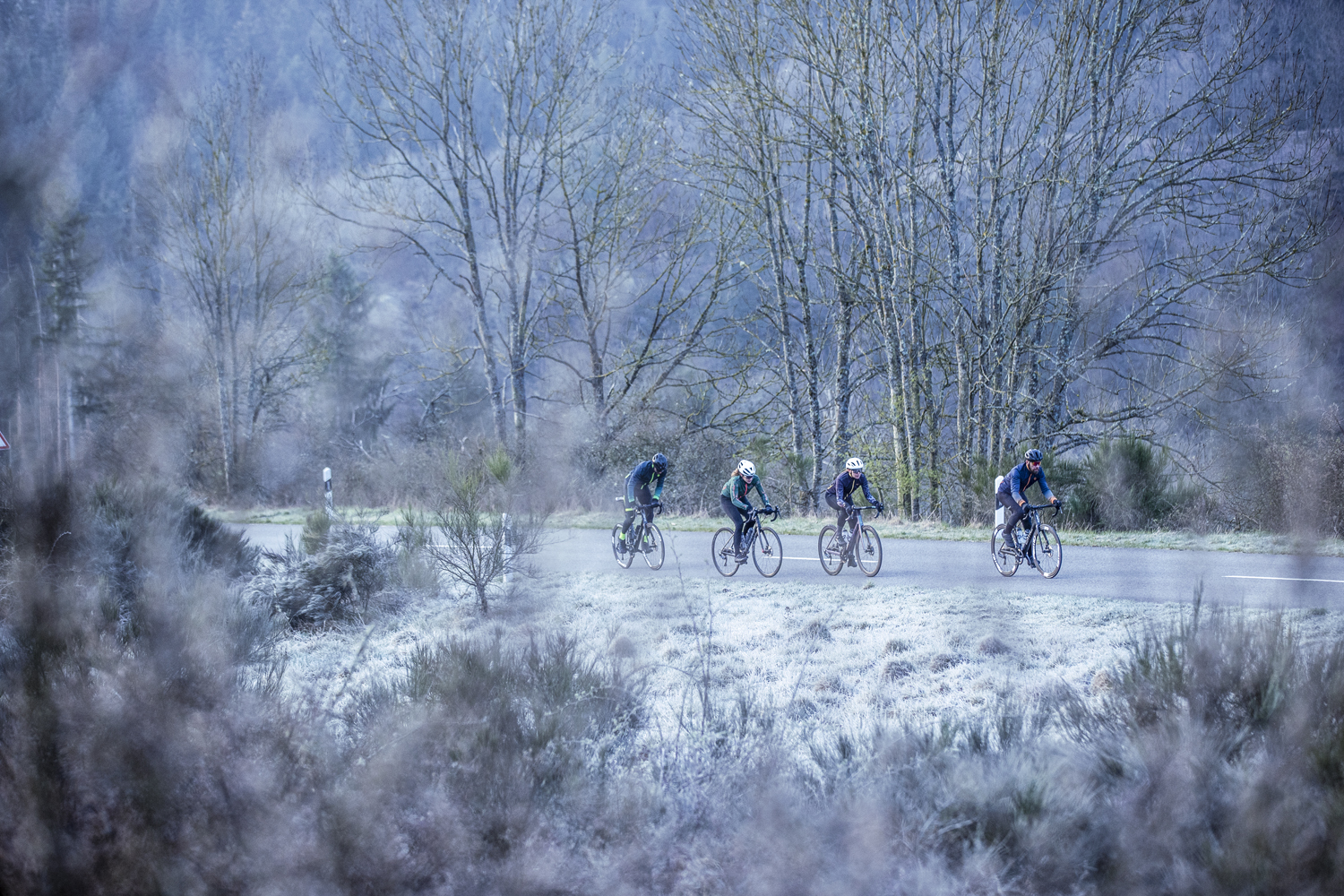 Groep wielrenners rijdt door koude omstandigheden gekleed in warme Rogelli fietskleding.